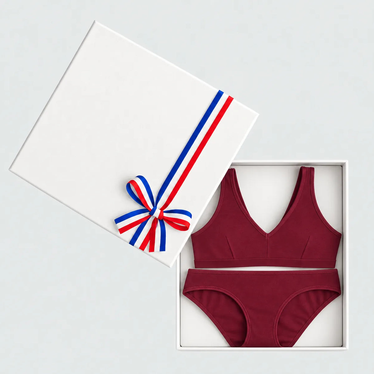 Coffret cadeau lingerie bordeaux ouvert : brassière à pince et culotte en coton bio, couvercle à ruban tricolore