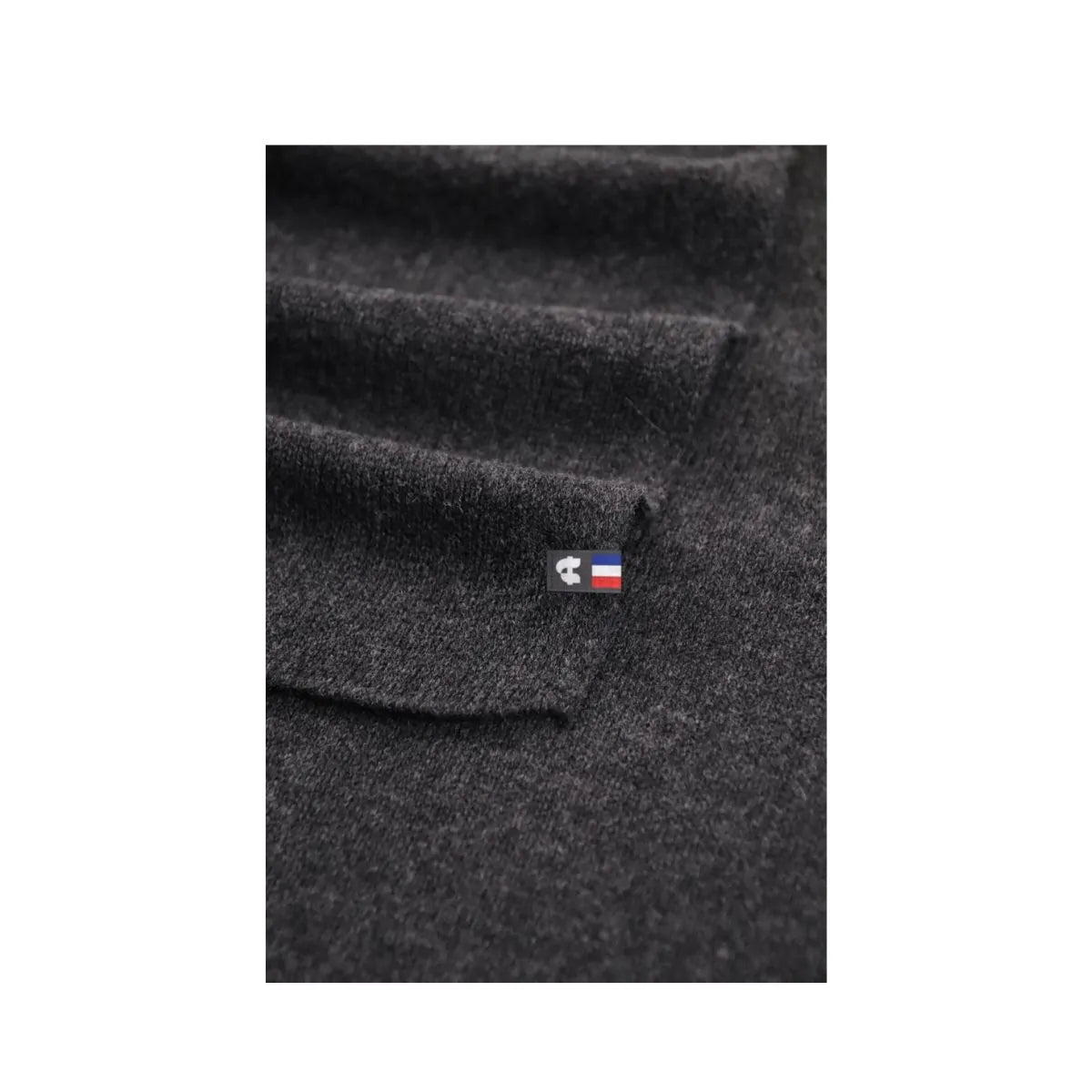 Détail de la maille de l'écharpe en cachemire noire pour homme et de son étiquette tricolore