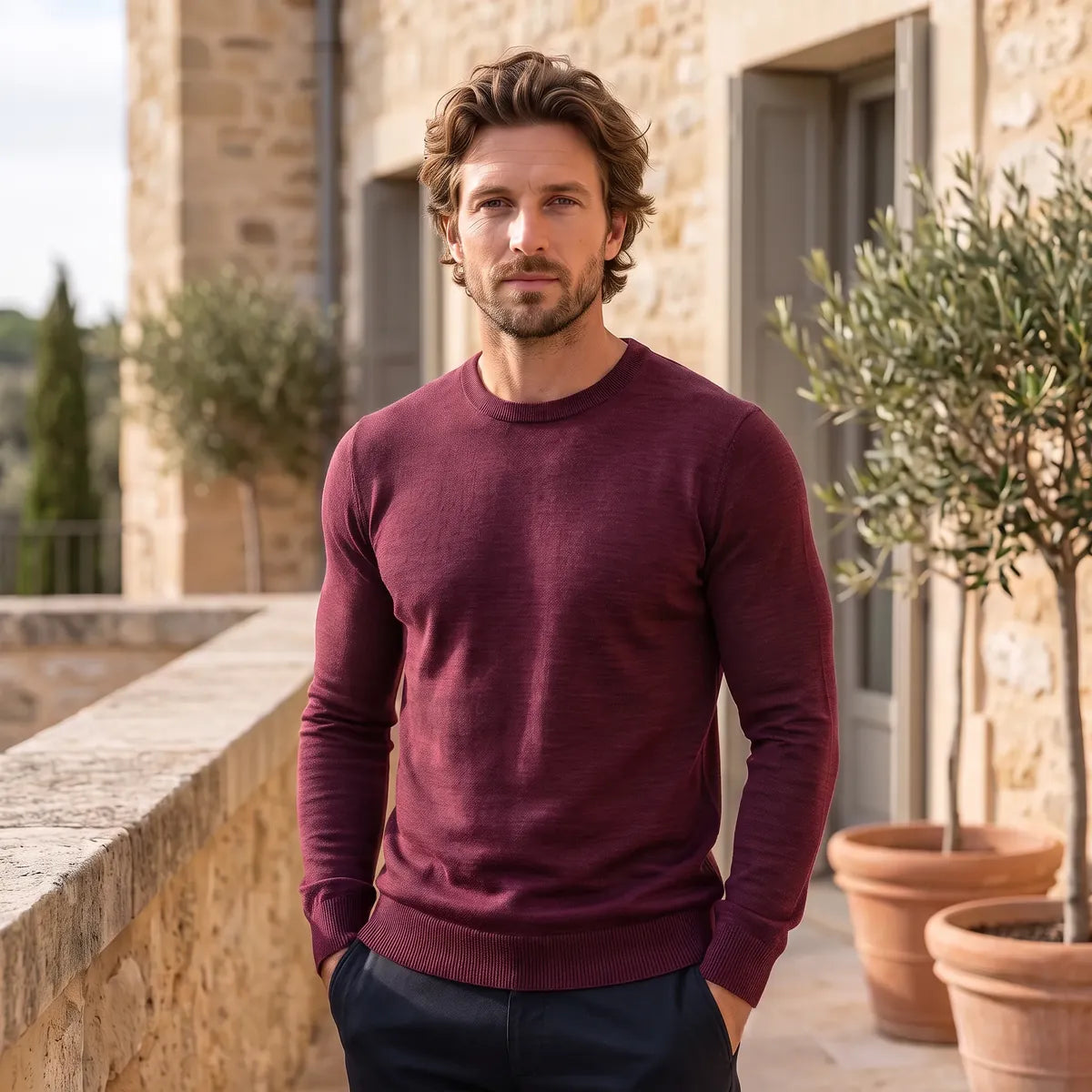 Homme portant le pull bordeaux en laine mérinos à col rond, avec un pantalon bleu marine