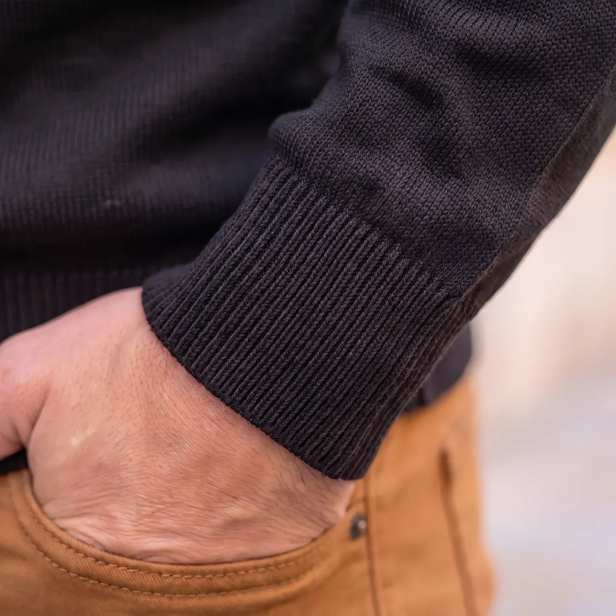Poignet et bas du pull noir en laine mérinos, finitions en bord côte fin