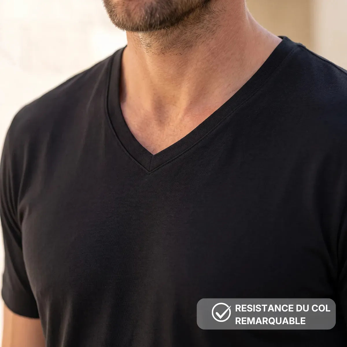 Détail de l'encolure en V du t-shirt noir en coton biologique