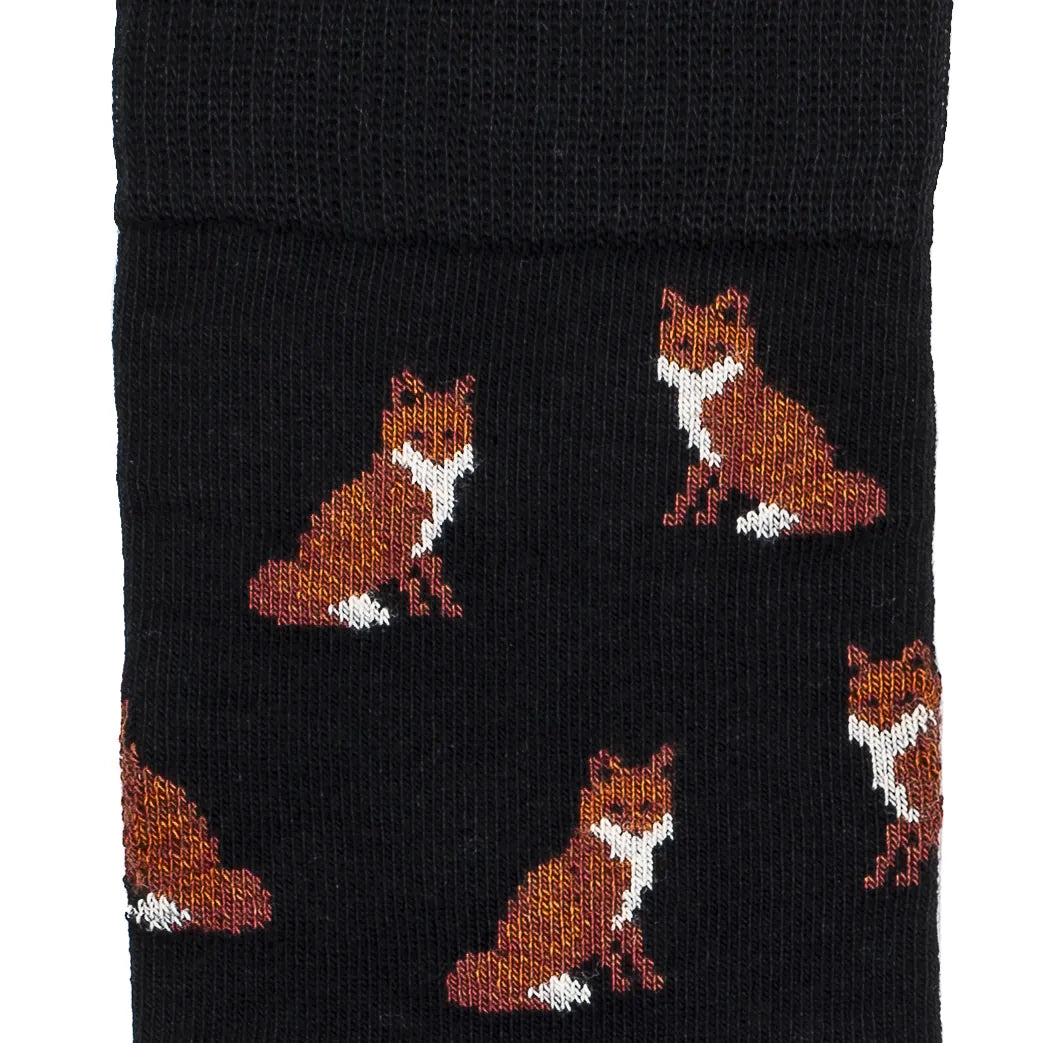 Détail des renards roux assis tricotés sur fond noir