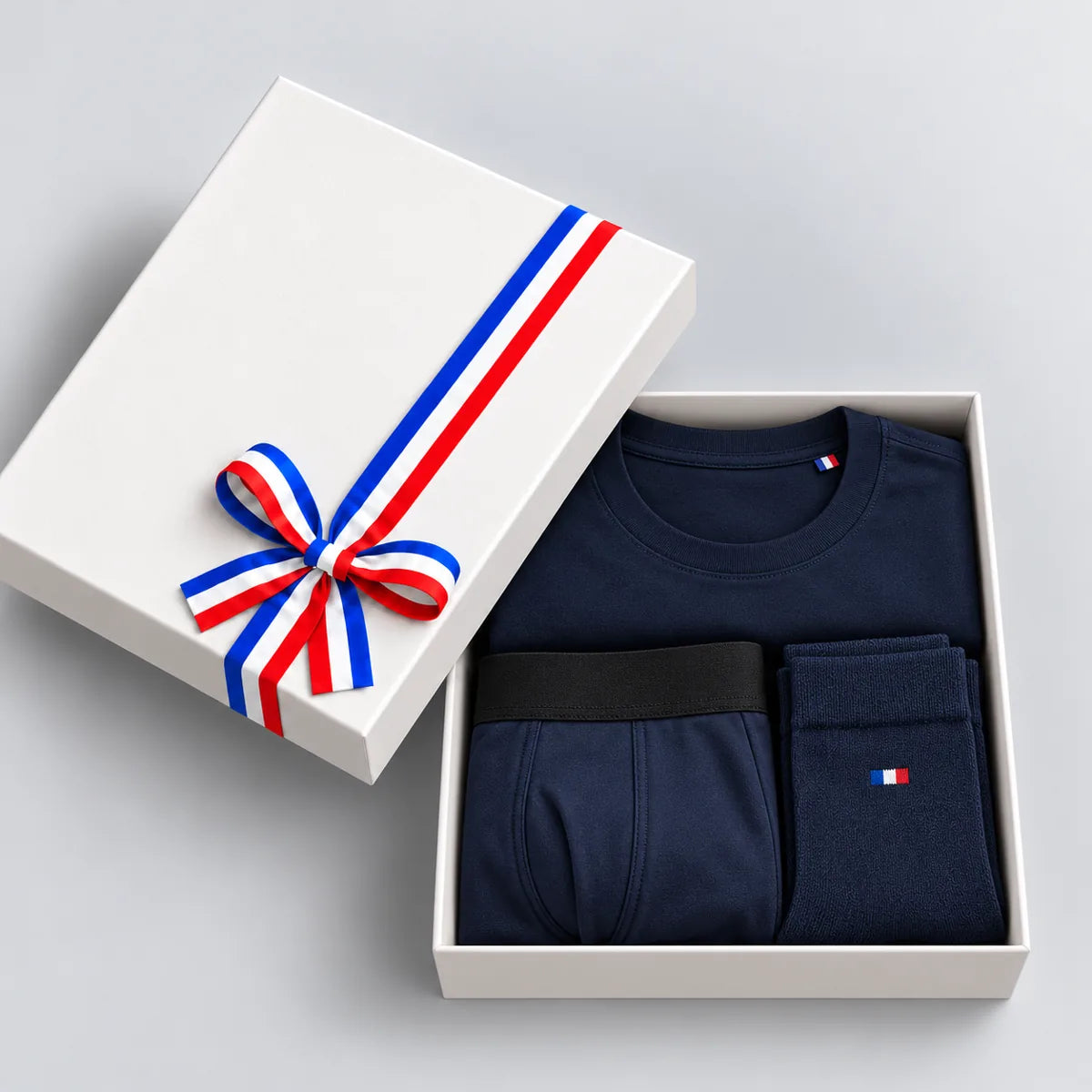 Coffret cadeau homme ouvert : t-shirt, boxer et chaussettes bleu marine, couvercle à ruban tricolore